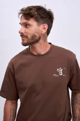 Remera marrón de manga corta y cuello redondo, con un pequeño estampado blanco de una cafetera moka en el pecho.