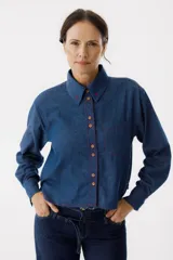 Camisa de manga larga en denim azul con detalles de costuras rojas y corazones bordados en el cuello.