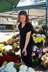 Vestido negro de lino con cuello y manga corta, corte a la cintura con lazo ajustable.