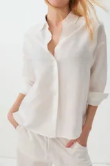 Camisa blanca de lino y algodón, de corte recto y mangas largas.