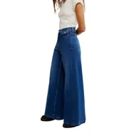 Jeans de mezclilla azul oscuro, estilo palazzo o pierna ancha, con tiro alto y bolsillos delanteros pequeños con solapa.