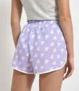 Short de pijama femenino estilo runner, color lila con estampado de corazones blancos, cintura elástica y lazo de ajuste blanco.