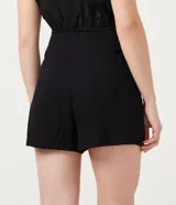 Short pollera negro de viscosa con cierre de cremallera trasero, corte mini y diseño cruzado con abertura frontal.