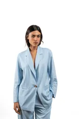 Blazer celeste de lino, con solapas de muesca, cierre frontal con dos botones, mangas largas con puños abotonados y bolsillos delanteros con solapa.