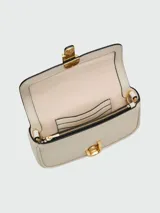 Bolso bandolera Marc Jacobs The Mini, color crema, con correa ancha de tela con logo de la marca y cadena dorada decorativa.