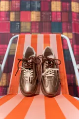 Championes de cuero color cobre con doble cordón, suela marrón y detalles en blanco.