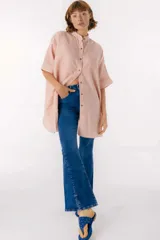 Camisa color salmón con rayas verticales blancas, cuello mao, manga corta con terminación en puño, botones de metal a la vista y tajos laterales.