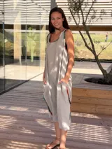 Vestido midi de lino color crudo, con cuello redondo, sin mangas, corte recto, tajos laterales y bordados a mano en ruedo y sisas.