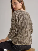 Buzo de punto color beige con diseño geométrico en negro. Incluye cuello alto y falda cruzada a juego.