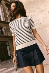Top de punto color crema con rayas horizontales azul marino, cuello redondo y mangas cortas.