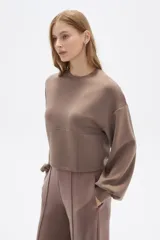 Buzo color marrón con cuello redondo y mangas largas abullonadas.