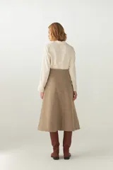 Falda midi evasé color beige, tejida en lana fina con detalle de pespuntes y cierre oculto.
