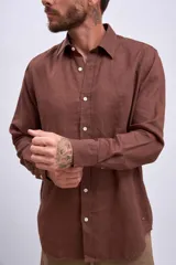 Camisa de lino color crudo, de corte recto, con cuello clásico y mangas largas.