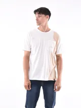 Remera negra de corte oversized con bolsillo en el pecho y detalle de bloque gris en el lateral.