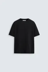 Camiseta negra de corte relaxed fit, confeccionada en tejido de algodón compacto con estructura piqué. Cuello redondo y manga corta.