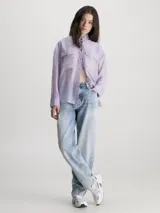 Camisa Calvin Klein de lyocell color lila, de corte holgado, manga larga, cuello en punta, cierre de botones, bolsillos con solapa en el pecho y logo bordado en el bolsillo del pecho.