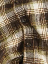Sobrecamisa de manga larga con cierre de botones, bolsillos en el pecho con cierre de botón y fit relajado. Diseño a cuadros en tonos marrón, beige y blanco.