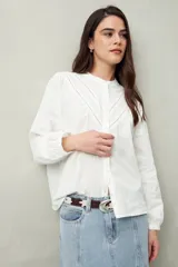 Camisa blanca de algodón con cuello mao, mangas abullonadas con puños abotonados y calados centrales.