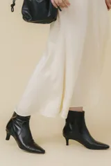 Botín de cuero vacuno negro con taco chupete y punta fina.