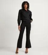 Pantalón flare negro confeccionado en viscosa, con botón en forma de corazón y abertura en los laterales.