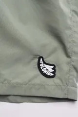 Short de baño en color gris, diseñado para actividades acuáticas y deportivas, con cintura elástica y bolsillos con cierre.