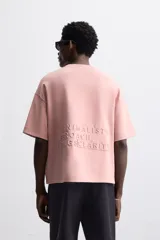 Camiseta rosa de corte recto, cuello redondo y manga corta. Estampado con efecto grabado combinado a tono en la espalda.