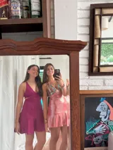 Vestido corto de lentejuelas color verde oliva, con escote en V, breteles finos cruzados en la espalda, cut-outs laterales y volado en el ruedo.