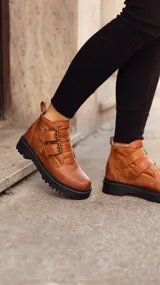 Botas negras de cuero con dos hebillas y suela gruesa.