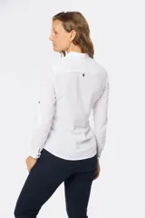 Camisa blanca de lino con mangas largas, cuello clásico, medio abotonada y bolsillo en el pecho. Tiene presilla en la manga para mayor comodidad.