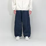 Pantalón de jean azul oscuro, corte ultra baggy, con costuras blancas a contraste y un rayo bordado en el bolsillo lateral.