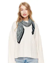 Pañuelo cuadrado de poliéster plisado, color blanco roto, con estampado paisley en tonos malva y gris. Presenta un borde liso en tono malva oscuro.