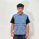 Chaleco de denim celeste con cuello camisero, cierre frontal con botones metálicos, dos bolsillos frontales con solapa y logo bordado en el pecho.