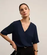 Blusa azul marino de crepé airflow, con escote en V tanto en la parte delantera como en la espalda, mangas cortas y sin estampado.