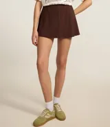 Short pollera marrón de punto roma con cintura elástica y recortes verticales.