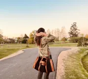 Bolso de viaje grande de cuero vacuno color negro con detalles en marrón. Tiene herrajes metálicos, gran superficie interna, asa de mano y correa para el hombro.