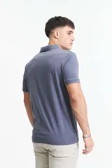 Remera polo azul grisáceo de estilo jersey, corte regular y logo estampado en el pecho.