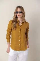 Camisa de manga larga color mostaza, confeccionada en lino.