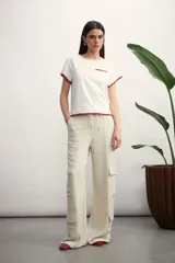 Remera blanca de mangas cortas con bolsillo en el pecho y ribete tostado en mangas, cuello y bolsillo.