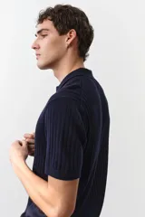 Remera polo de manga corta color azul marino en punto acanalado de mezcla de algodón con cuello y medio cierre. Remate acanalado de raya fina en mangas y bajo. Corte ajustado que realza el contorno del cuerpo creando una silueta entallada.