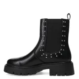 Bota negra con elástico lateral y tachas decorativas, de suela gruesa.