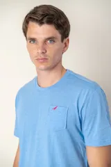 Remera azul con cuello redondo, manga corta, bolsillo en el pecho y logo bordado.
