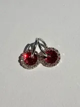 Aros pequeños plateados con dije redondo de resina roja con glitter y strass.