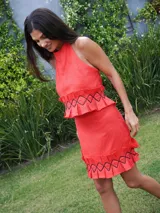 Pollera corta color marrón rojizo, con textura arrugada y volados en el ruedo. Presenta detalles de costura negra en zigzag sobre los volados.