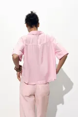 Camisa cropped color rosa de lino, con cuello solapa, escote pico, manga corta y bolsillos delanteros de plastrón.
