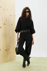 Pantalón de jean negro de corte amplio, con tiro alto y detalles de costuras en las piernas.