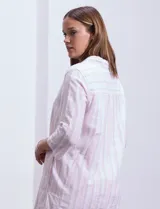 Vestido corto de algodón a rayas verticales en tonos beige, gris y blanco. Tiene cuello solapa, escote en V, mangas 3/4 regulables con presilla y botón, y bolsillos laterales.