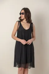 Vestido corto negro de seda con breteles finos anudados en los hombros y escote en V.