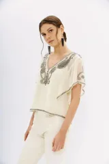 Blusa color crema de georgette con bordado de piedras, mostacillas y canutillos. Tiene viso interior con puntilla.