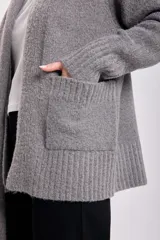 Cardigan tejido de punto color gris claro, con cuello chal y lazo para atar.