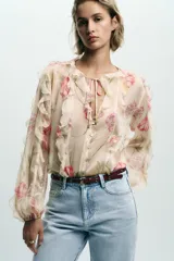 Pantalón de jean celeste de tiro alto, corte recto y largo, con cinco bolsillos y cinturón marrón de cuero.